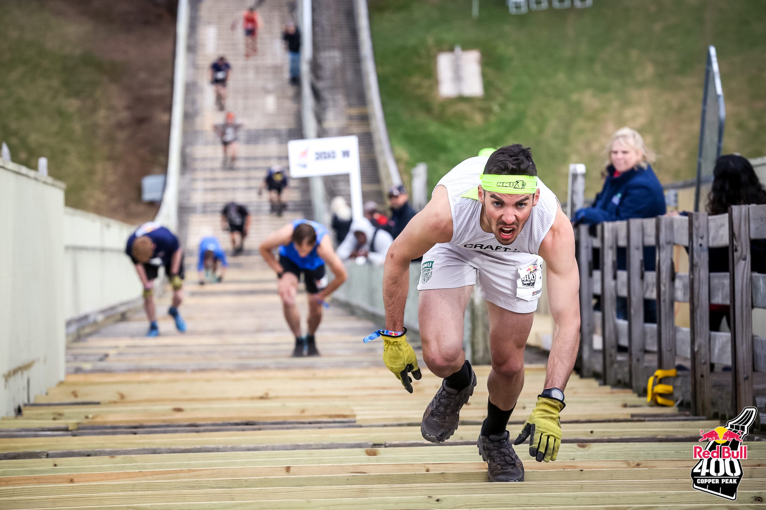 A person runs up a downhill ski jump during a competition.